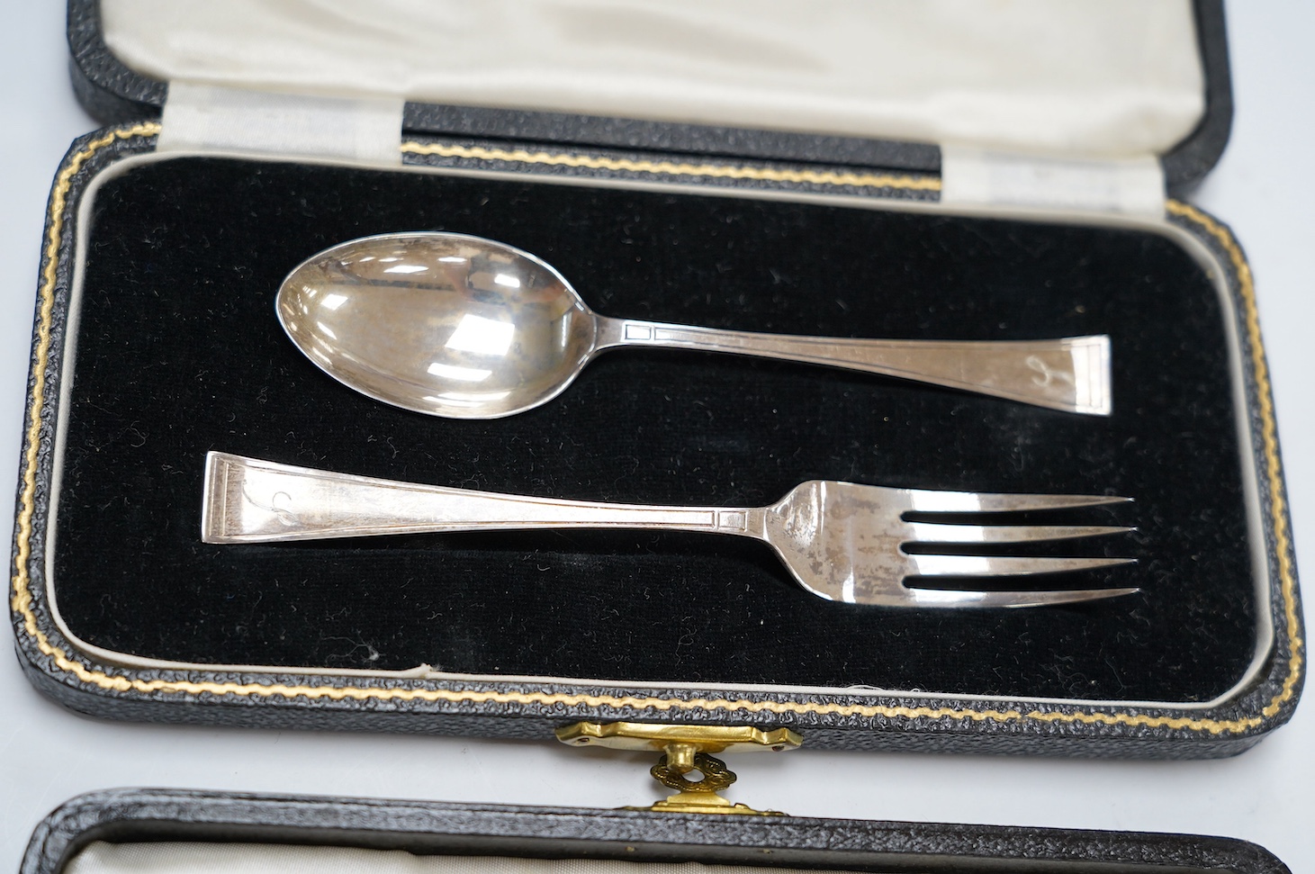 Two George V silver sauceboats and two cased flatware sets. Condition - fair
